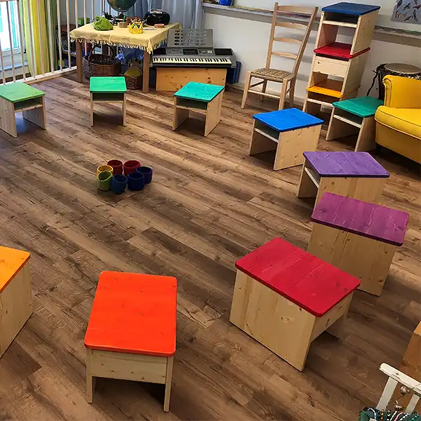 Sitzkreis mit farbigen Holzhockern Churermodell