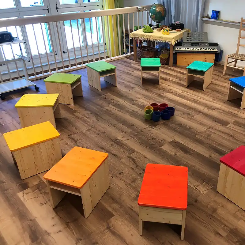 Sitzkreis mit farbigen Holzhockern Churermodell