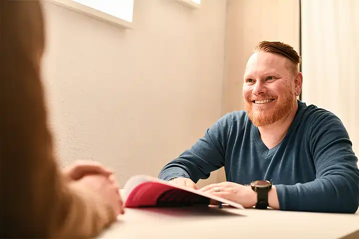 Mann mit Bart führt ein Beratungsgespräch durch