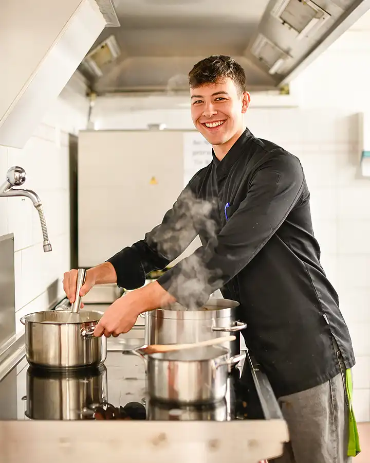 Junger Mann in der Küche, bereitet eine Mahlzeit zu