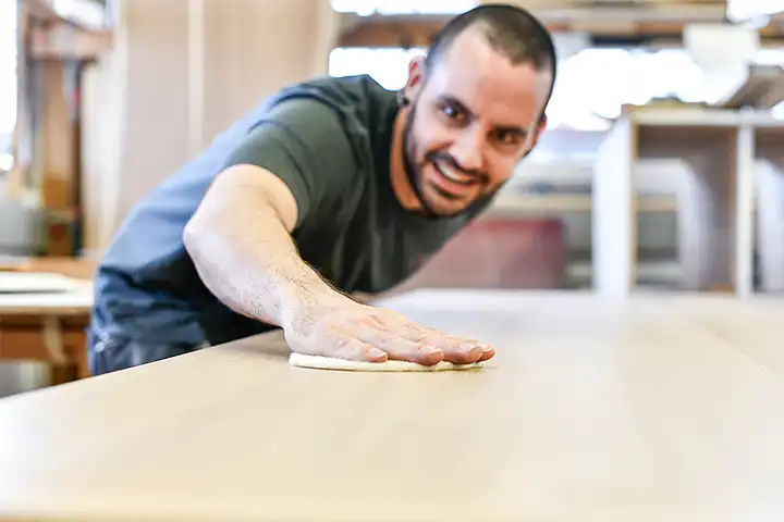 Schreiner beim Abschleifen eines Tisches