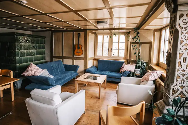gemütliches Wohnzimmer im Rehazentrum mit Sofas und Kachelofen