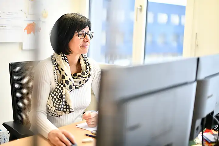 Frau mit schwarzen Haaren arbeitet am Computer
