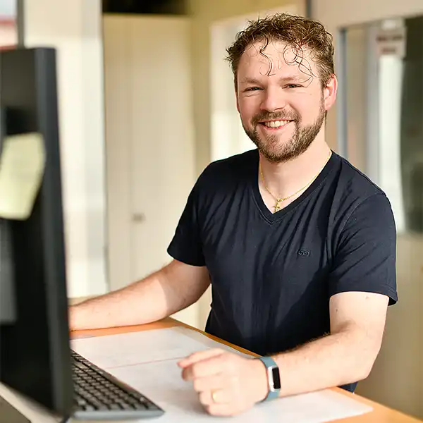 Mann arbeitet am Computer und lacht