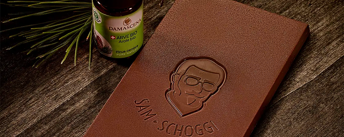 Leckere Schokoladentafel mit kleiner Flasche Arvenöl und Arvenzweig