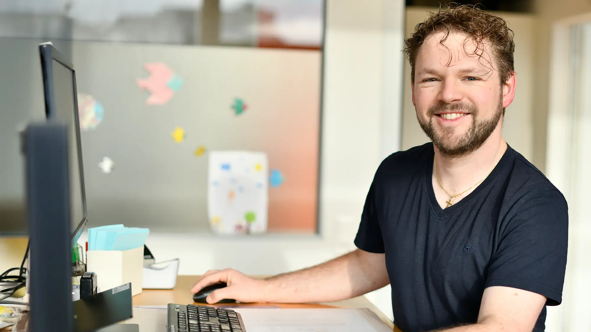 Mann arbeitet am Computer und lacht