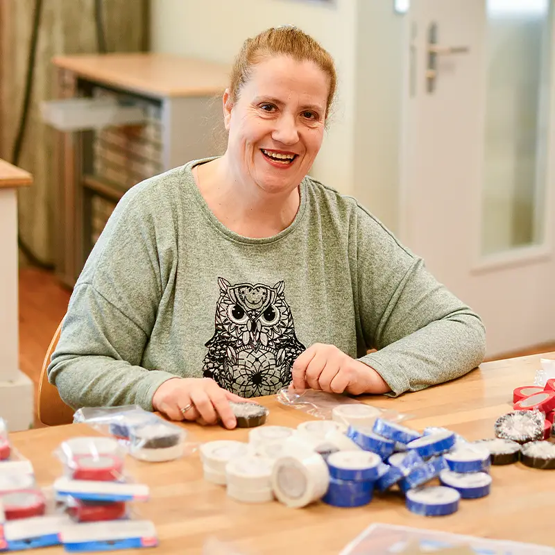 Frau mit blonden Haaren arbeitet in Konfektion